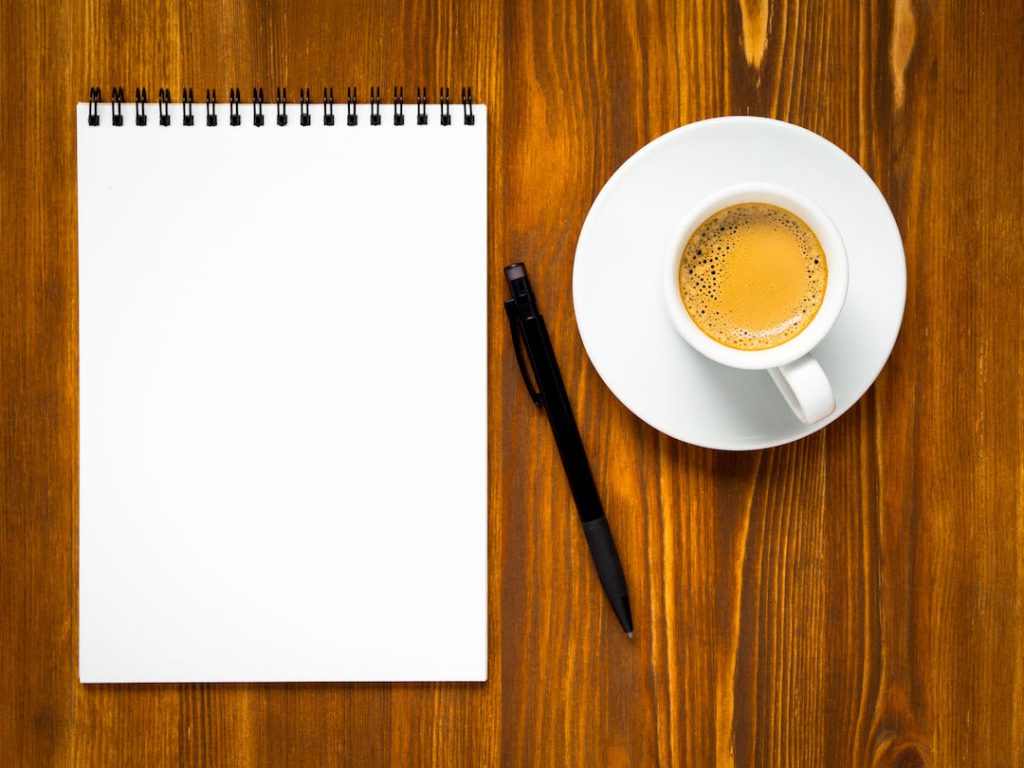 Coffee mug and empty note-pad | Featured image for What You Need to do Before Investing in Property blog